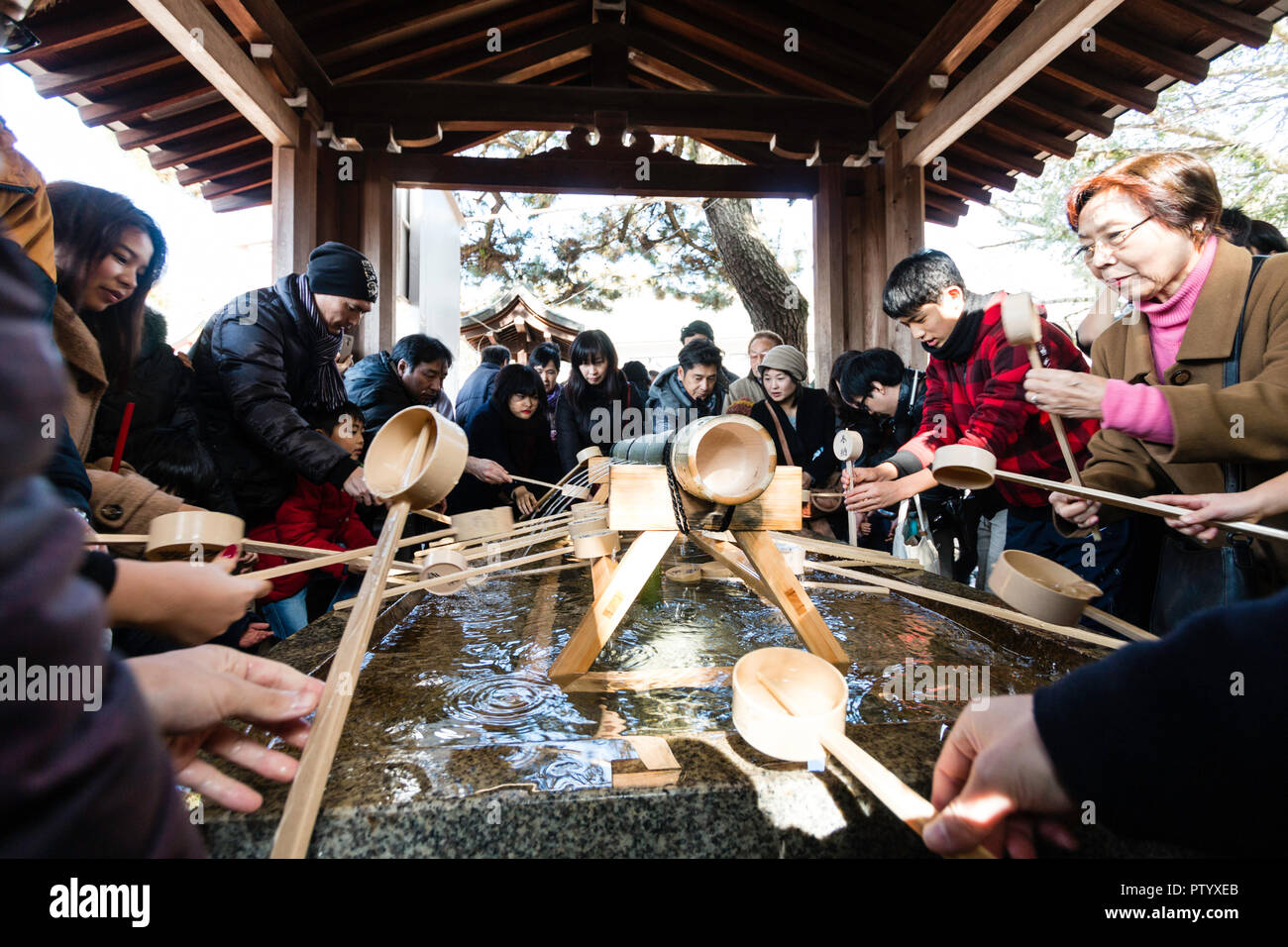 Japanische neues Jahr, shogatsu. menschen Durchführung temizu, Wasseraufbereitung auf der sehr belebten chozuya, aka temizuya vor dem Eintritt in das Heiligtum. Stockfoto