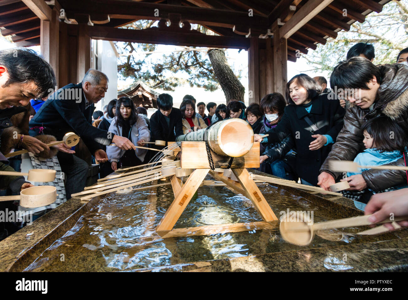 Japanische neues Jahr, shogatsu. menschen Durchführung temizu, Wasseraufbereitung auf der sehr belebten chozuya, aka temizuya vor dem Eintritt in das Heiligtum. Stockfoto