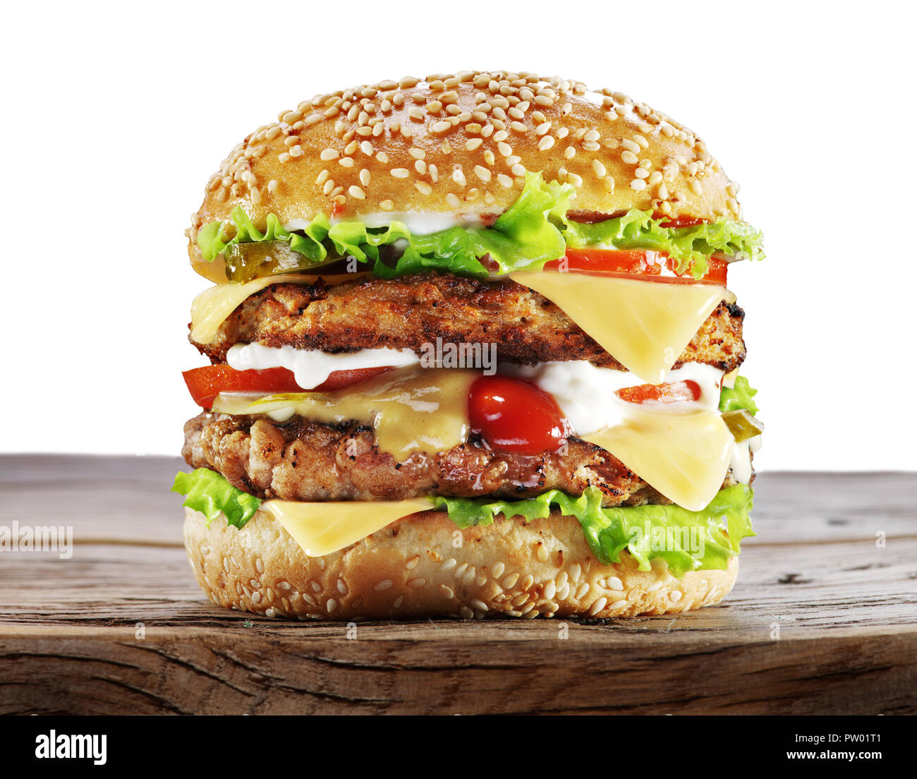 Große Hamburger auf Holztisch. Weißer Hintergrund. Freistellungspfad Stockfoto