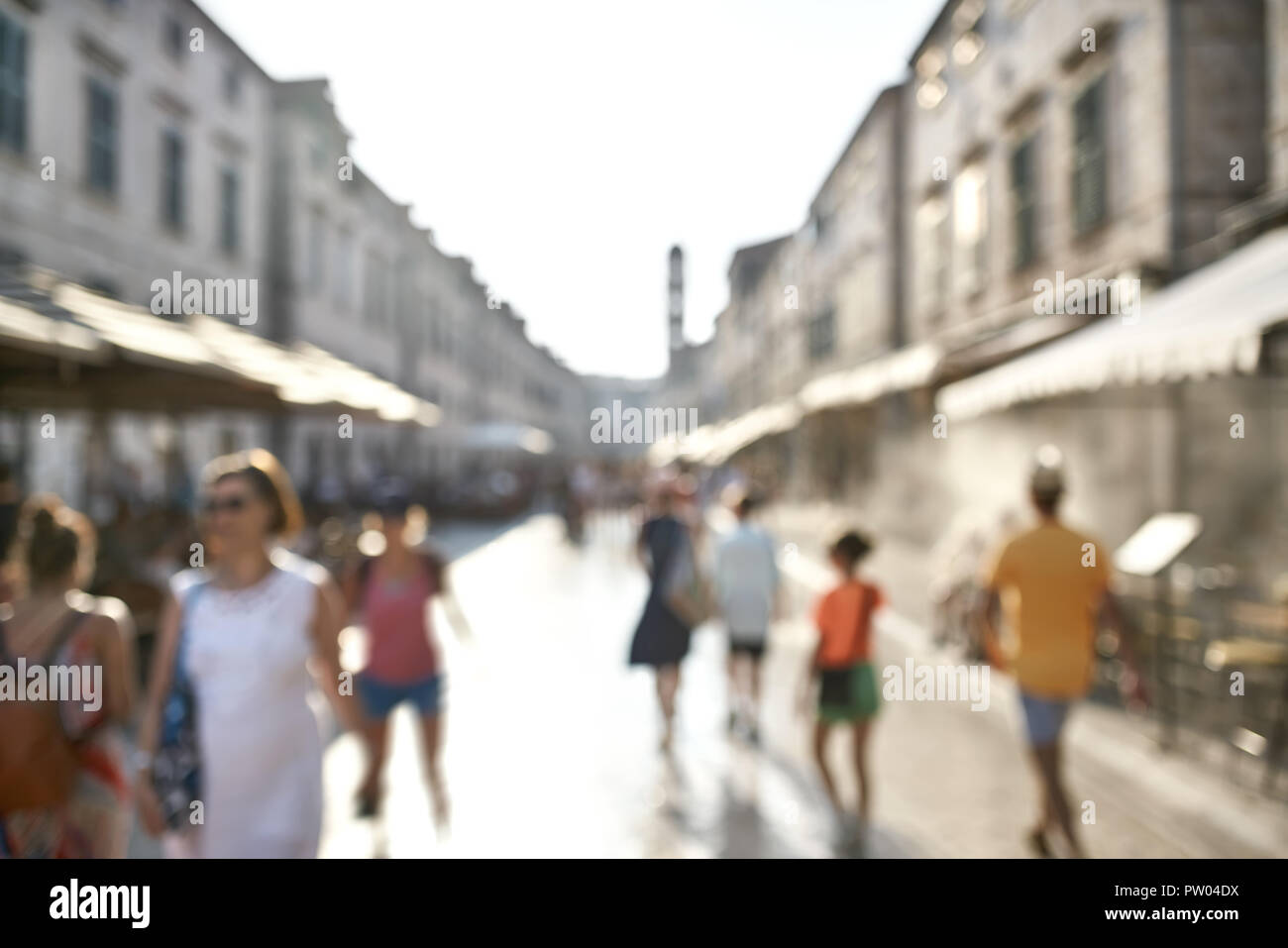 Touristen sind zu Fuß auf der sonnigen alten Straße in Dubrovnik in Kroatien. Verschwommen niedrige Blende horizontale Foto. Stockfoto