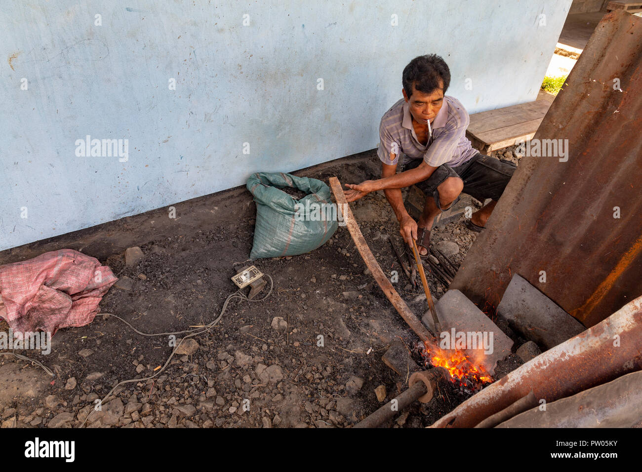 LUANG PRABANG, LAOS - OKTOBER 8: Ein unbekannter Mann rührt Kohlen und erwärmt sich Metall an einem in Luang Prabang, Laos am 8. Oktober 2017 zu schmieden. Stockfoto