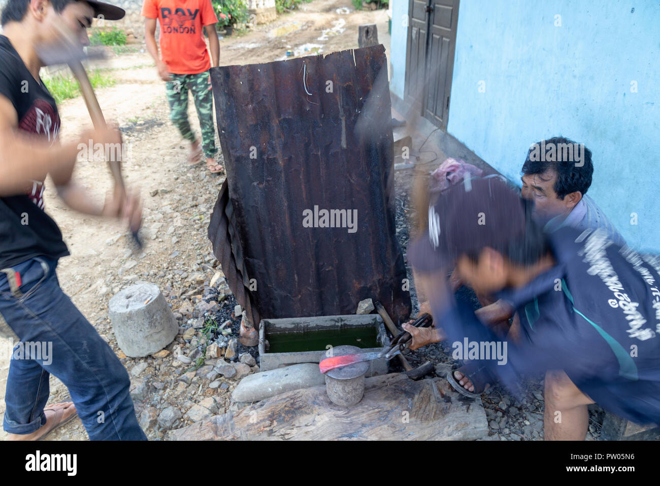 LUANG PRABANG, LAOS - OKTOBER 8: Ein unbekannter Mann schleift ein traditionelles Laos Schwert in einem lokalen Dorf in Luang Prabang, Laos am 8. Oktober, 201 Forge Stockfoto