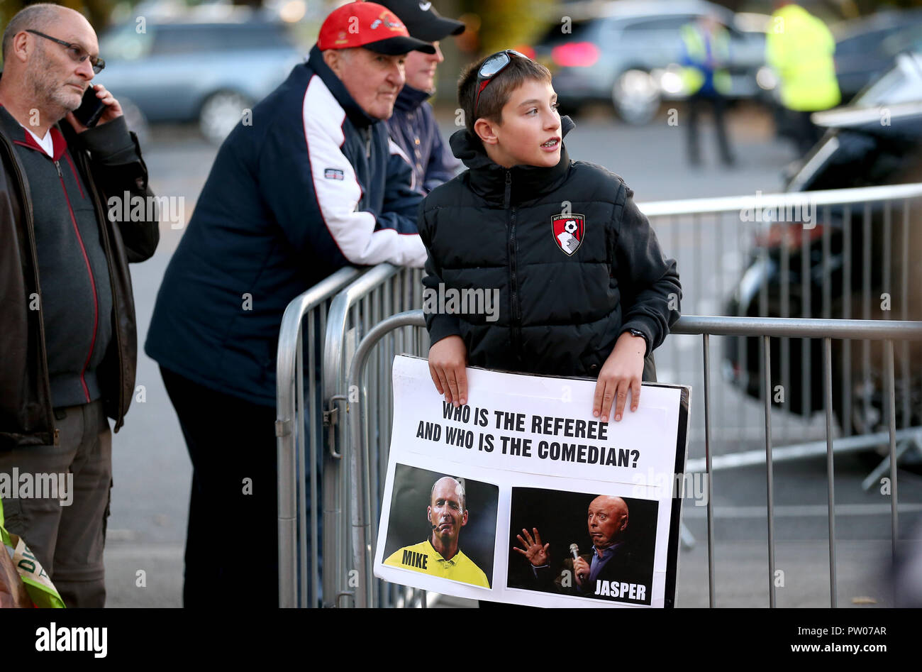 Ein AFC Bournemouth fan hält ein Schild vergleich Schiedsrichter Mike Dean zu Komiker Jasper Karotte vor der Premier League Match an der Vitalität Stadion, Bournemouth Stockfoto