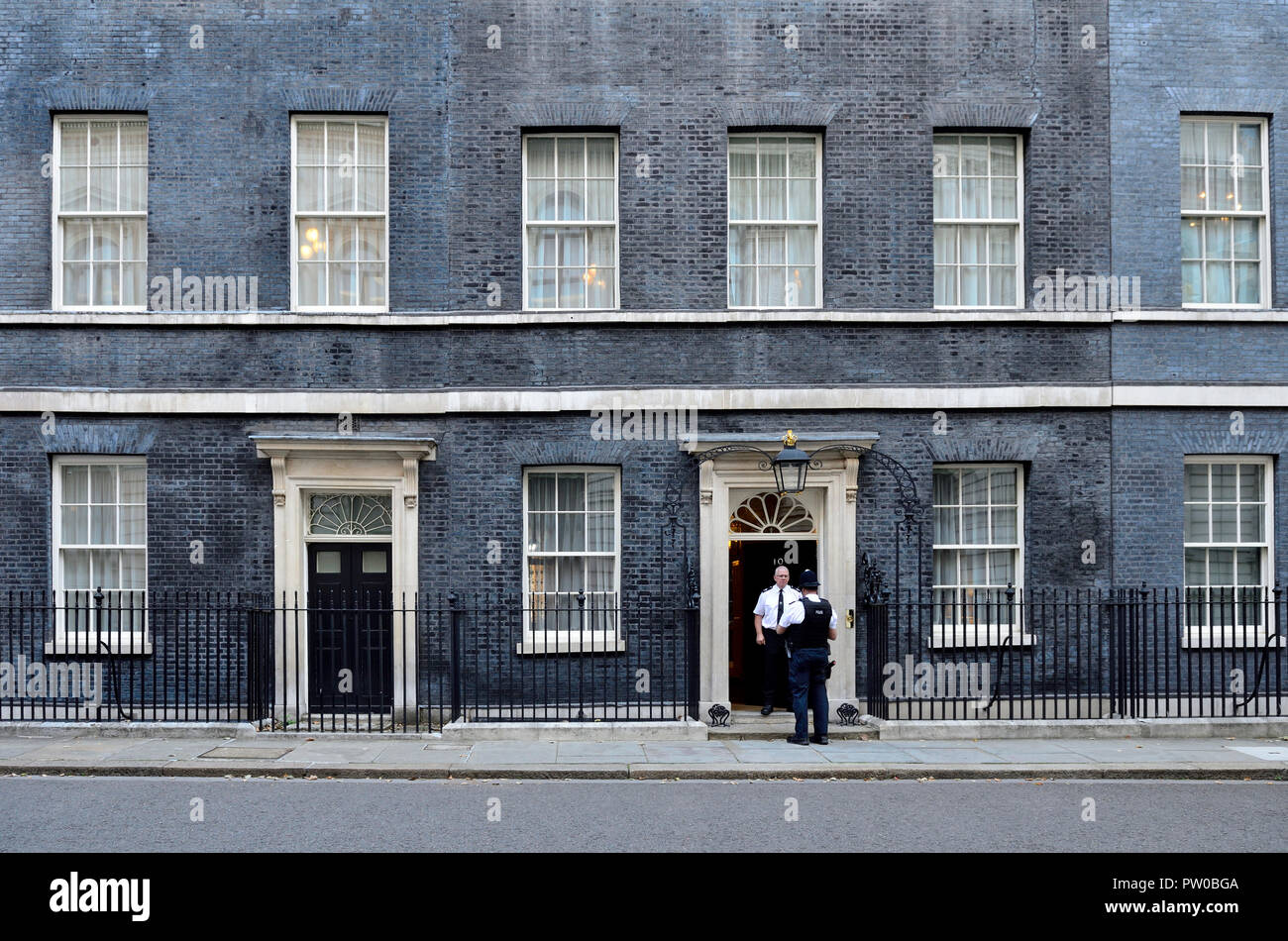 Zwei Polizisten sprechen in der Tür Nr. 10 Downing Street, London, England, UK. Stockfoto