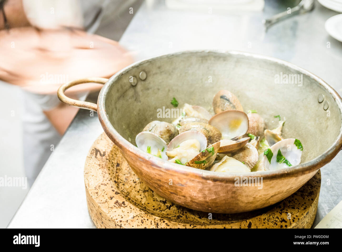 Teil der Muscheln gebraten mit Knoblauch und Koriander in einem kupfernen Topf im Restaurant Stockfoto