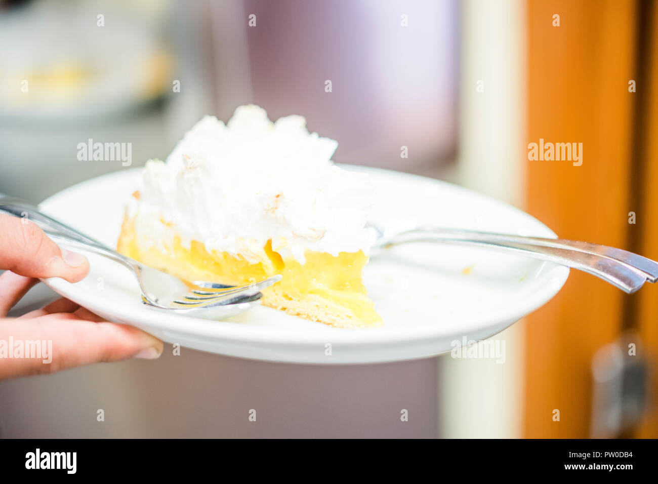 Lemon Meringue Pie auf weiße Platte halten von Man Stockfoto