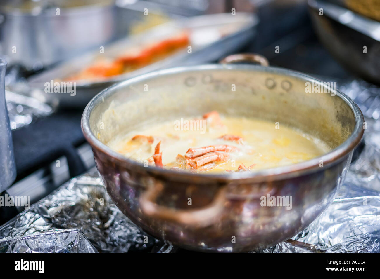 Hummersuppe auf Basis von Milch und Rotwein in Kupfer Topf zubereitet Stockfoto