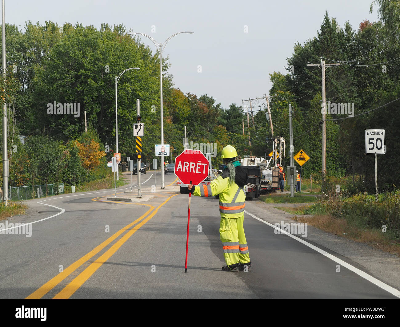 Quebec, Kanada. Ein flag Frau stoppen Verkehr auf Route 343 in Sainte-Marceline - Kildare Stockfoto