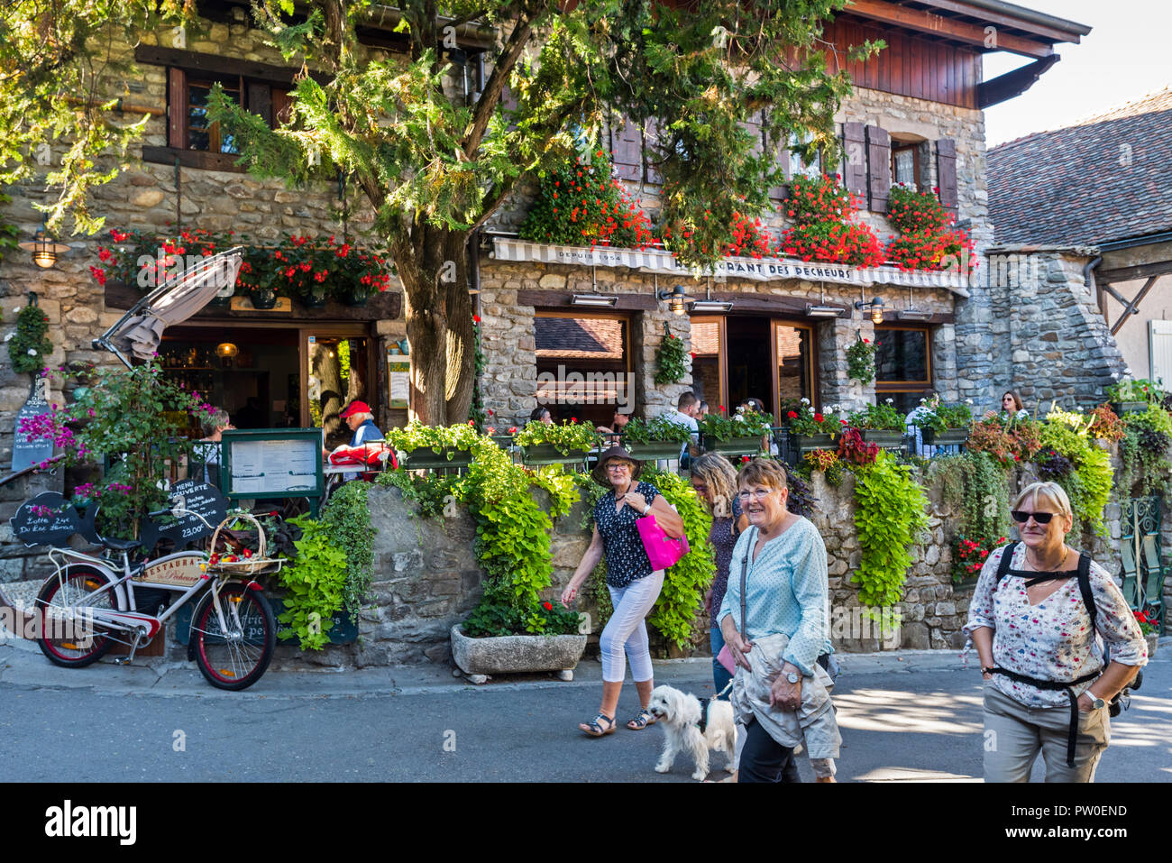 Ältere Touristen vor dem Restaurant im mittelalterlichen Dorf Yvoire, Haute-Savoie, Auvergne-Rh ône-Alpes, Frankreich Stockfoto