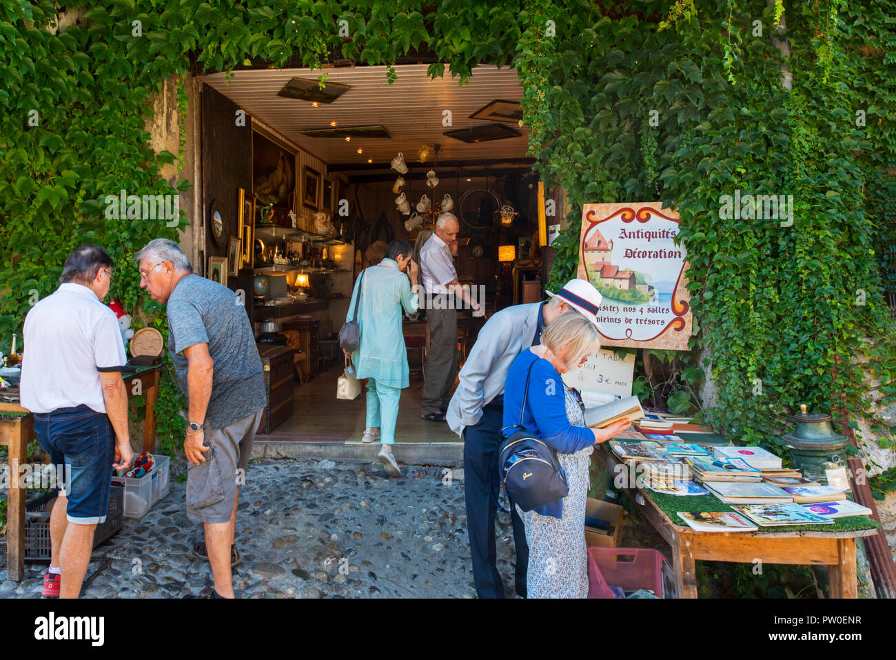 Touristen, die in antiken Shop/antiquarian im mittelalterlichen Dorf Yvoire, Haute-Savoie, Auvergne-Rh ône-Alpes, Frankreich Stockfoto