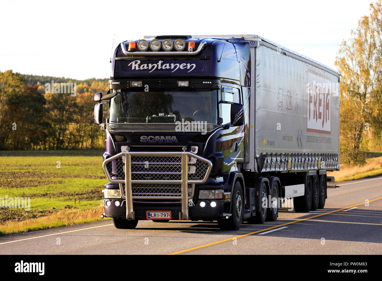 Salo, Finnland - 5. Oktober 2018: Lila Scania R500 Semi Truck von Pernion JR-Trans Ky hols Sattelcurtainsider entlang herbstliche Highway am Abend Stockfoto