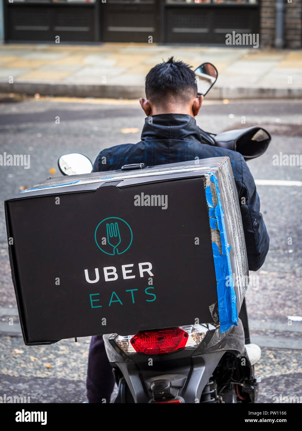 Uber isst Food Delivery Kurier für die nächste Lieferung Anfrage London UK Gig Wirtschaft UK wartet Stockfoto
