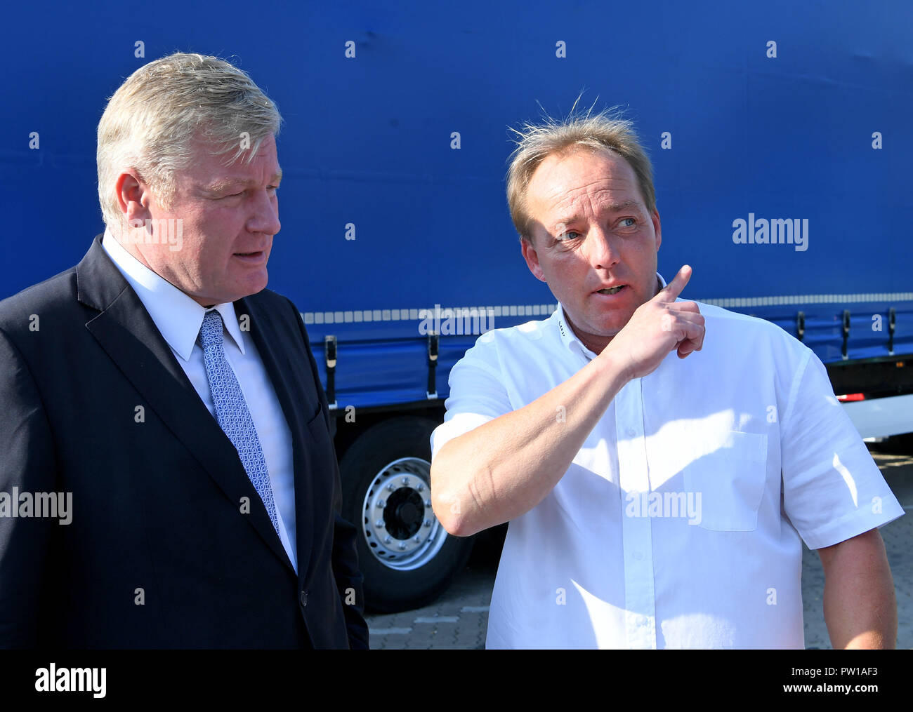 11 Oktober 2018, Niedersachsen, Auetal: Bernd Althusmann (CDU, l), Verkehrsminister von Niedersachsen und Busfahrer Steffen Reich (r) miteinander reden, während ein Lkw-Aktion Tag am Auetal Rastplatz auf der Autobahn A 2. Experten Treiber über Bremswege und Reaktionszeiten sowie die Gefahr der Müdigkeit am Steuer informieren. Der Anteil der Nutzfahrzeuge ist hoch auf der viel befahrenen Ost-west-Bundesautobahn 2 von der Ruhr über Westfalen und Hannover in Richtung Berlin. Mit einer Vielzahl von Maßnahmen, die Laender wollen jetzt mehr Sicherheit und eine schnellere Passage entlang der wichtigen arteriellen ro zu gewährleisten Stockfoto