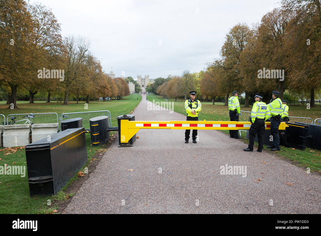 Windsor, Großbritannien. 12. Oktober, 2018. Polizeibeamte stehen durch feindliche Fahrzeug mitigation Hindernisse auf dem Langen im Windsor Great Park in der Vorbereitung für die Ankunft von gratulanten die Prozession nach der Hochzeit in St. George's Kapelle von Prinzessin Eugenie watch, Enkelin der Königin und Jack Brooksbank. Credit: Mark Kerrison/Alamy leben Nachrichten Stockfoto