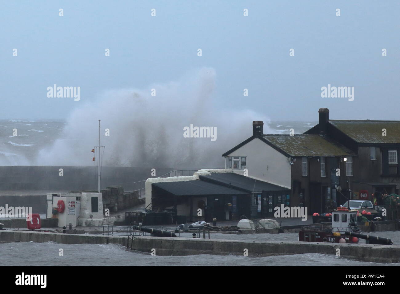 Lyme Regis, Dorset, Großbritannien, 12. Oktober, 2018: Großbritannien Wetter. Riesige Wellen, die durch Sturm Callum Hit der Cobb Hafen in Lyme Regis in Dorset. Credit: Savo Ilic/Alamy leben Nachrichten Stockfoto