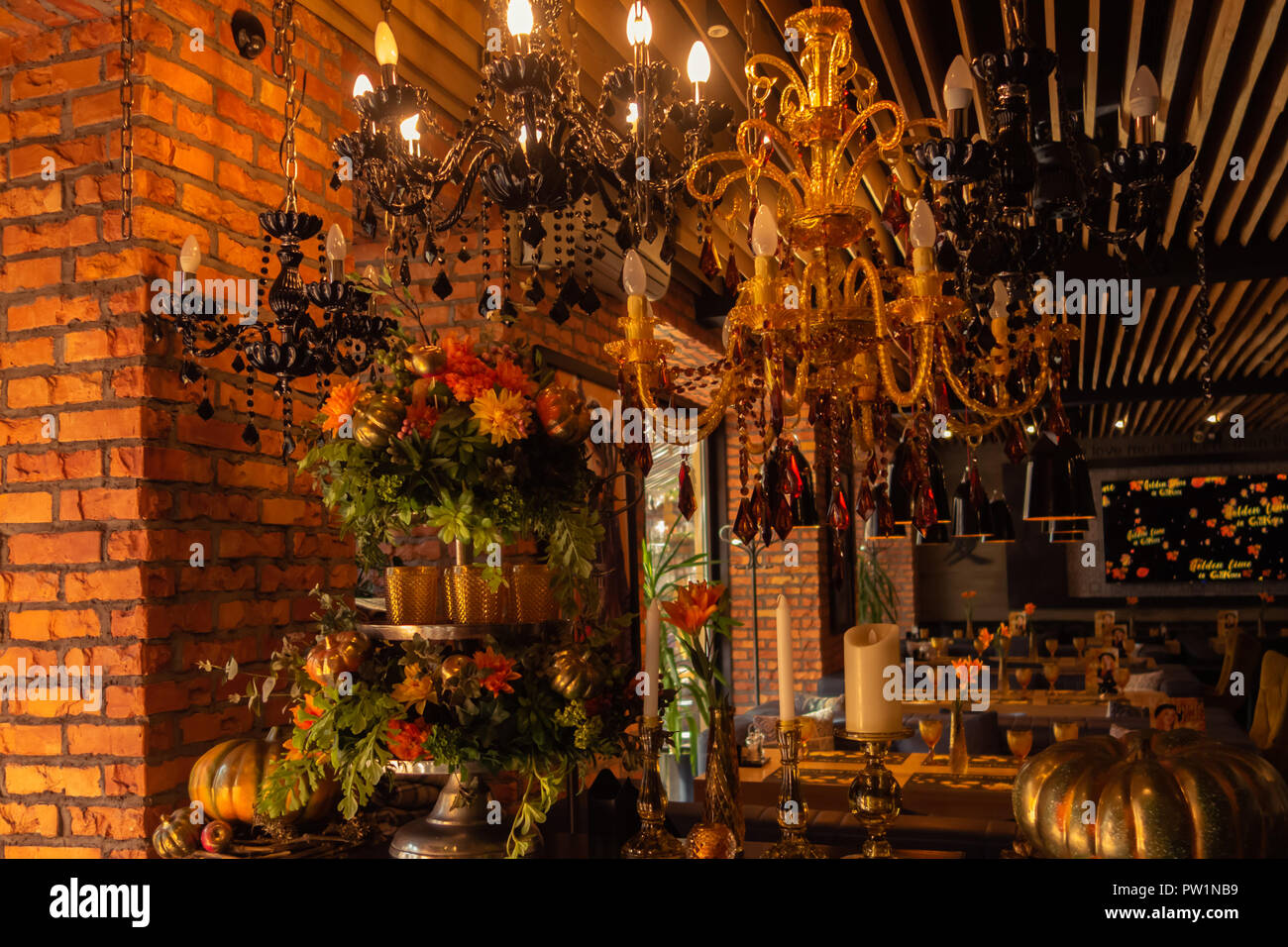 Ernte: eine Karre mit Kürbissen und Blumen im Park in der Nähe des Cafe. Ausstellung Goldener Herbst. Stockfoto