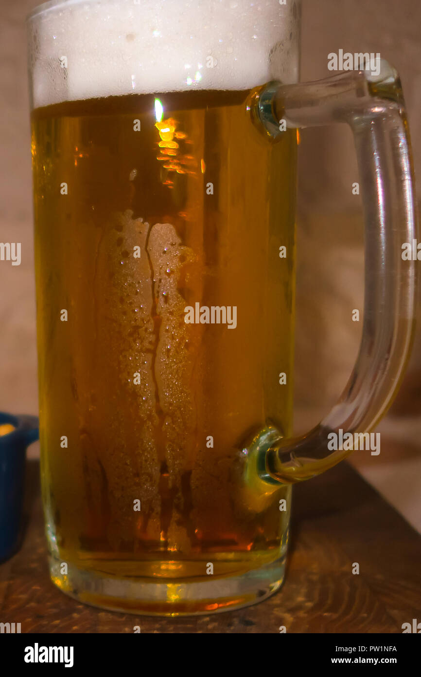 Glas Licht kalt schaumiges Bier, Muttern an einem alten Holztisch. Stockfoto