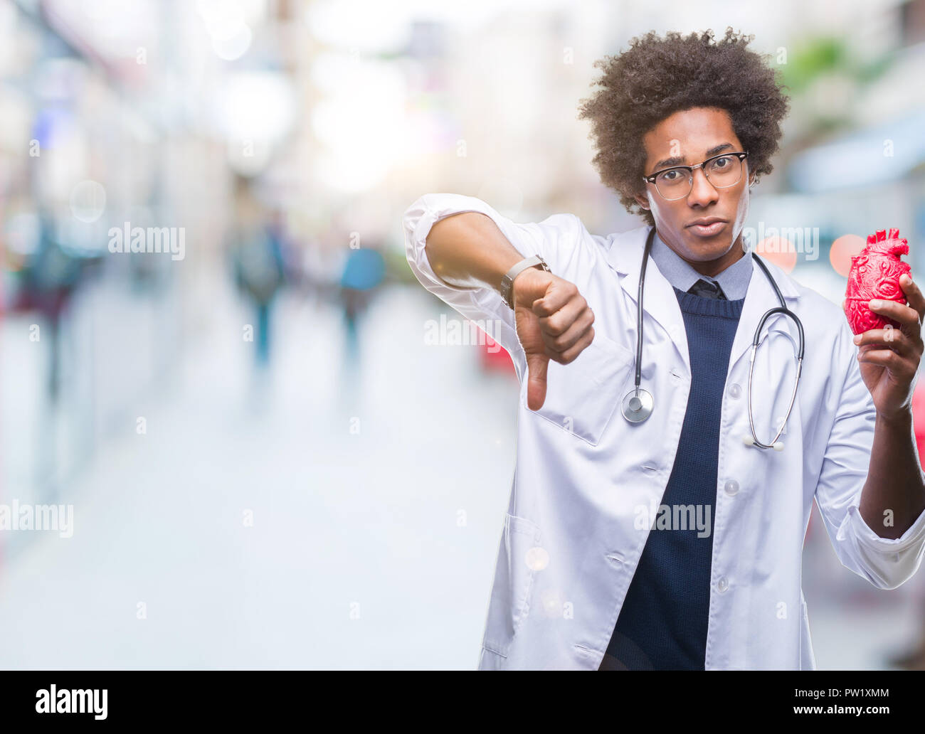 Afro-amerikanische Kardiologe Arzt Mann über isolierte Hintergrund mit Verärgerten Gesicht, negatives Vorzeichen zeigen Abneigung mit Daumen nach unten, Ablehnung Konzept Stockfoto