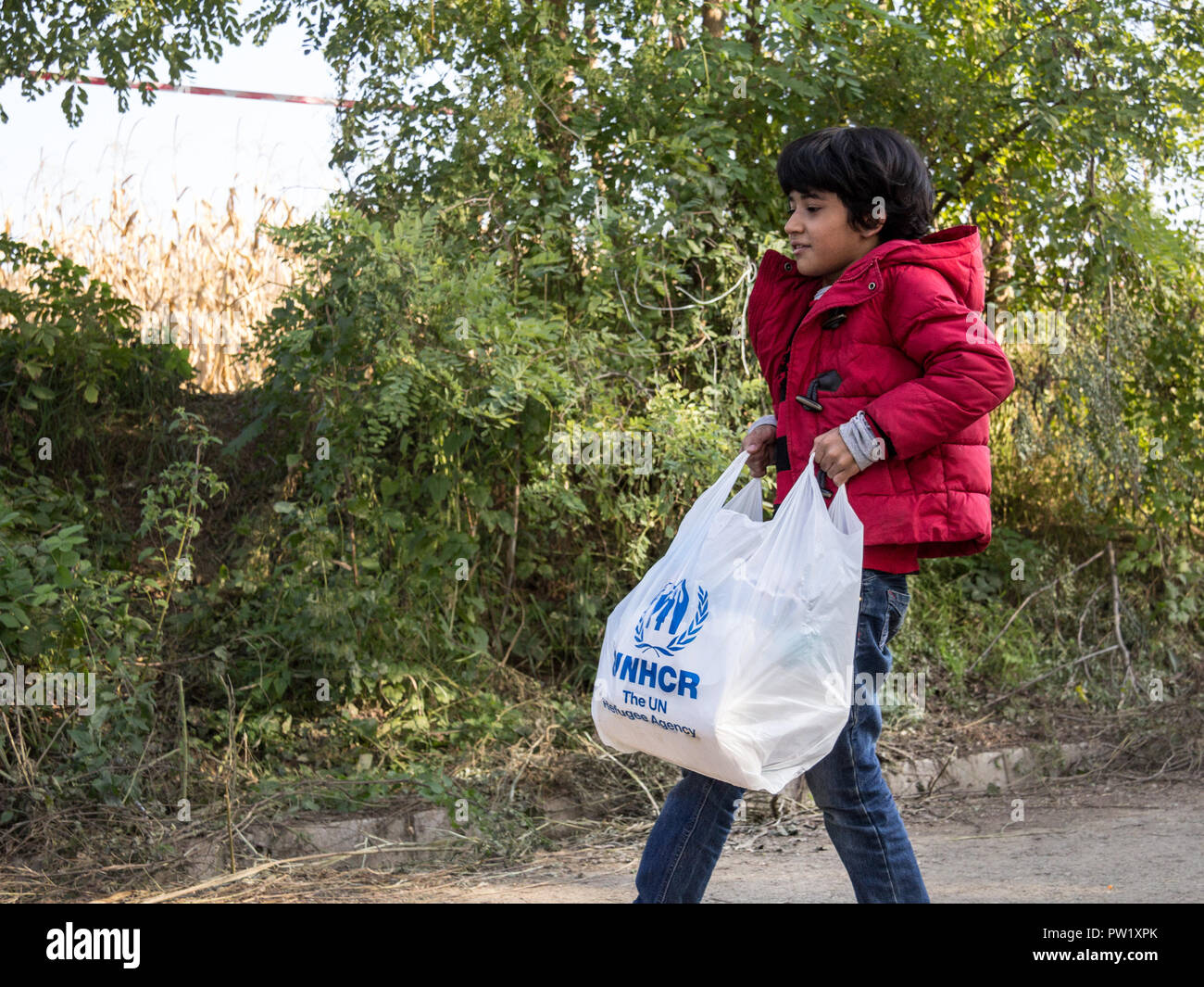 BERKASOVO, Serbien - Oktober 10, 2015: Flüchtling Kind eine schlechte humanitäre Hilfe mit dem Logo des UNHCR, der Sonderorganisation der Vereinten Nationen für refug Stockfoto