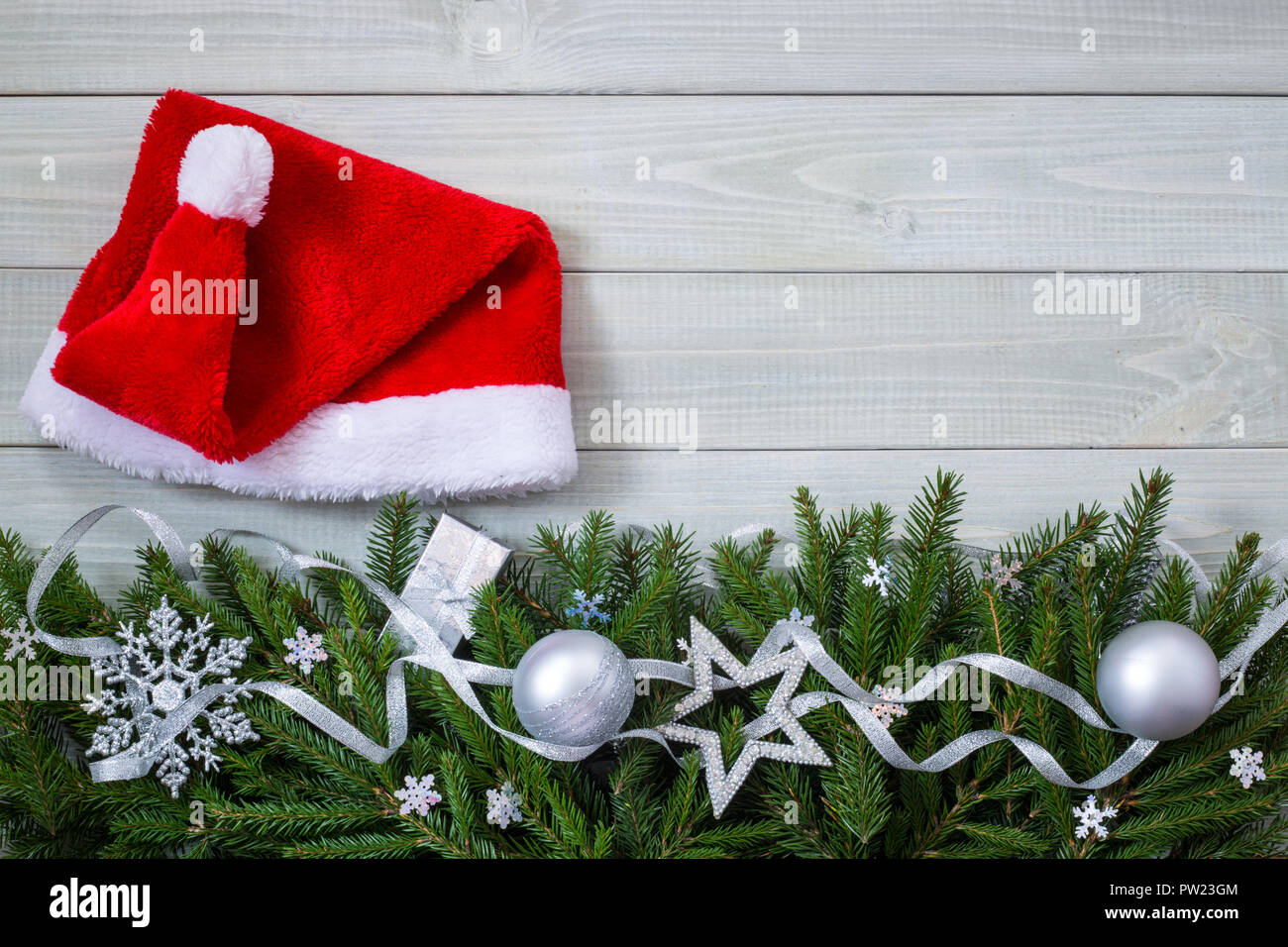 Weihnachten neues Jahr flach Christbaumkugel Dekor santa hut und Tannenzweigen auf Weiß getönten natürliche Holzbrett Hintergrund Textur im provenzalischen Stil mit Kopieren sp Stockfoto