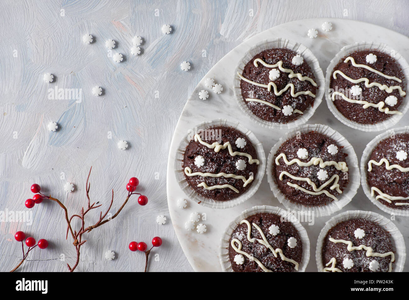 Flach mit dekorativen Roten berryies auf weißem Hintergrund im Landhausstil und Schokolade Muffins in white paper Cups für Weihnachten weiße Linien und Sn eingerichtet Stockfoto