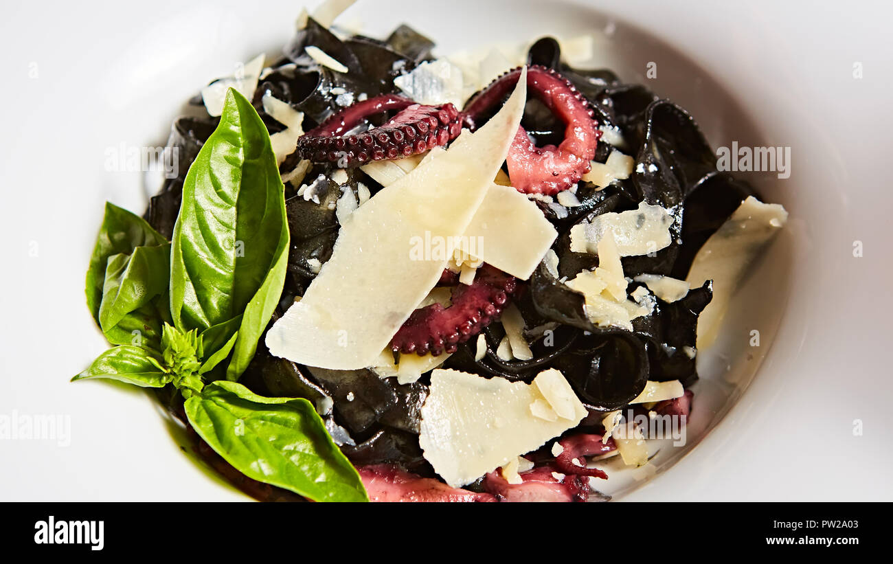 Pasta mit schwarzen Tintenfisch Tinte, Kraken und Parmesan. Stockfoto