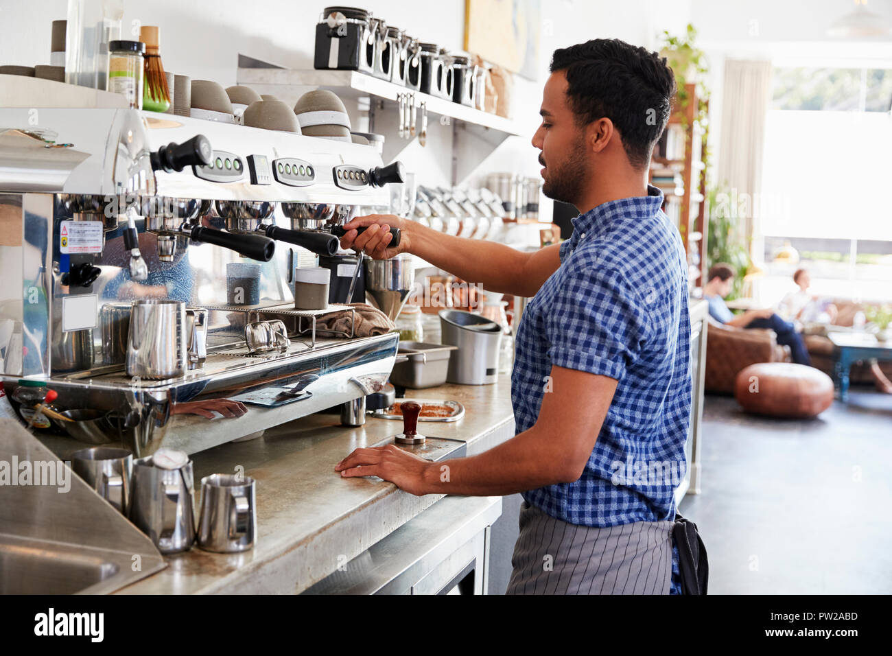 Junge männliche barista Vorbereitung Espresso in einem Café Stockfoto