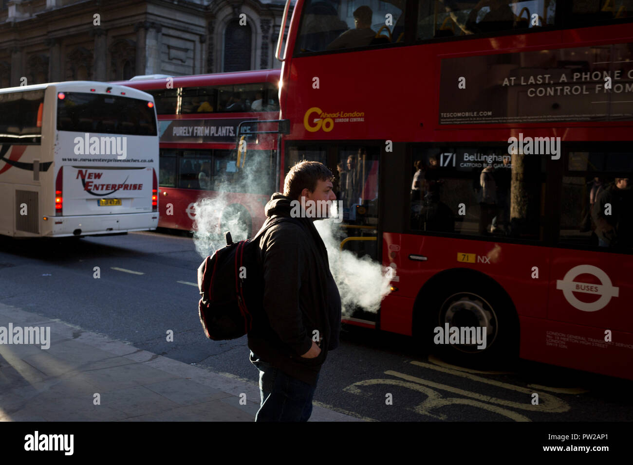 Eine vaper atmet vor dem Einsteigen in den Bus während des abendlichen Rush-hour in der Hauptstadt, die am 3. Oktober 2018, in London, England. Stockfoto