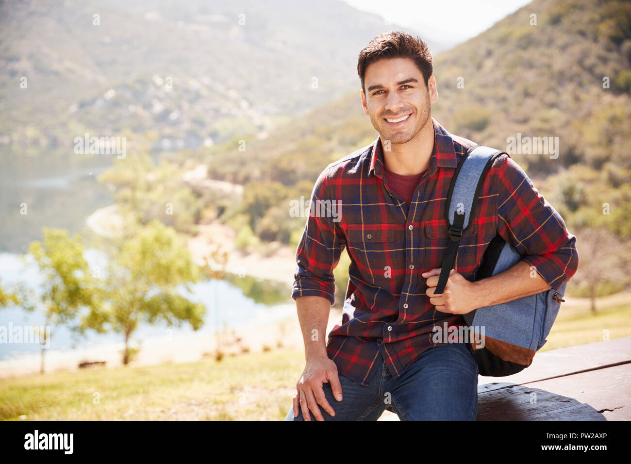 Junge Hispanic Mann während der Wanderung lächelnd, Porträt Stockfoto