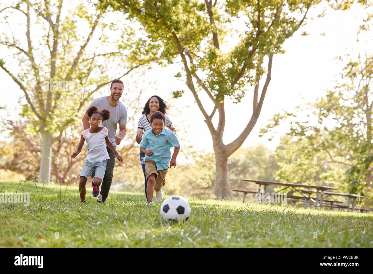 Familie zusammen spielen Fußball im Park Stockfoto