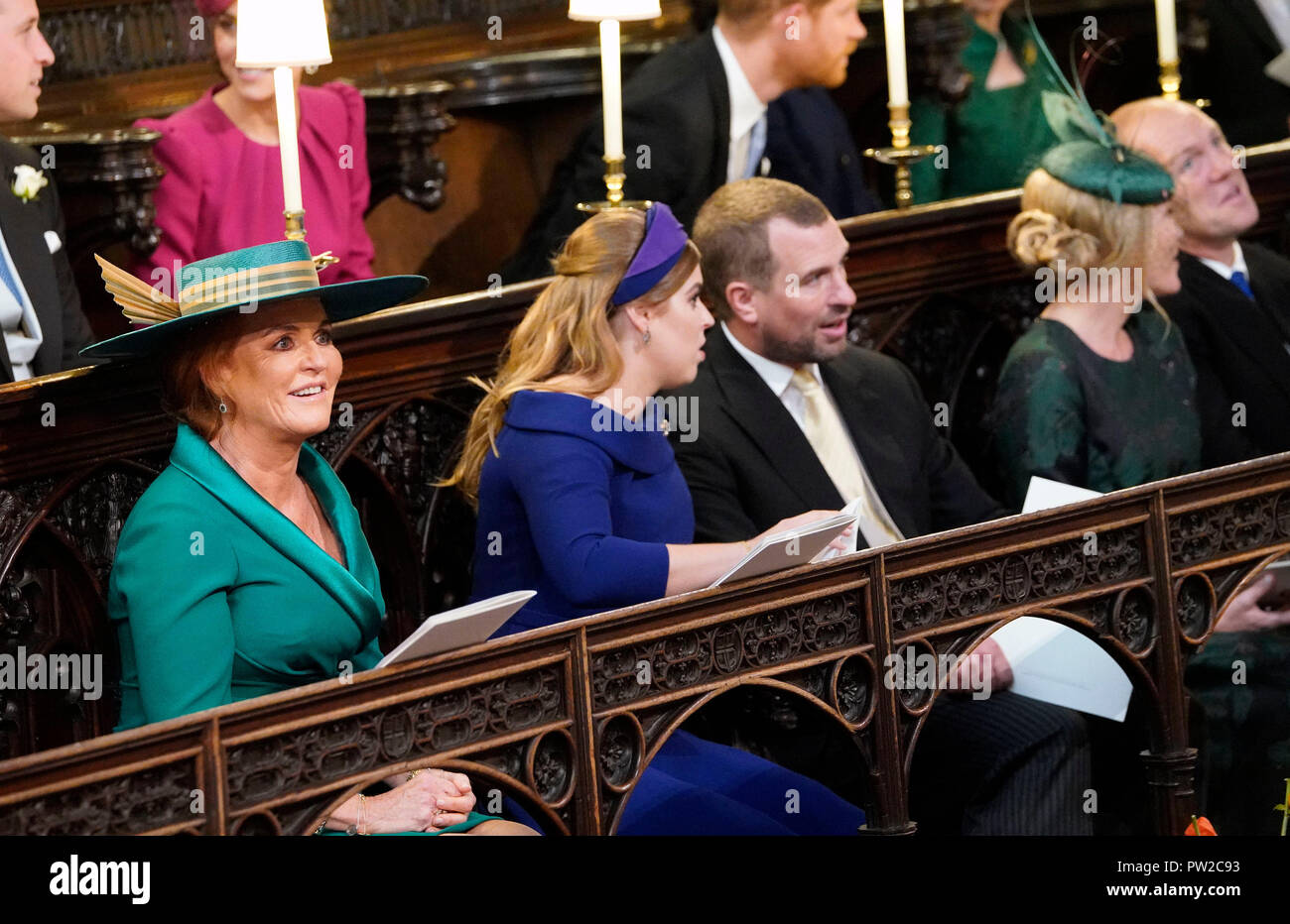 Sarah, die Herzogin von York, Prinzessin Beatrice von York und Peter Phillips nehmen ihre Plätze vor der Hochzeit von Prinzessin Eugenie an Jack Brooksbank im St George's Chapel in Windsor Castle. Stockfoto