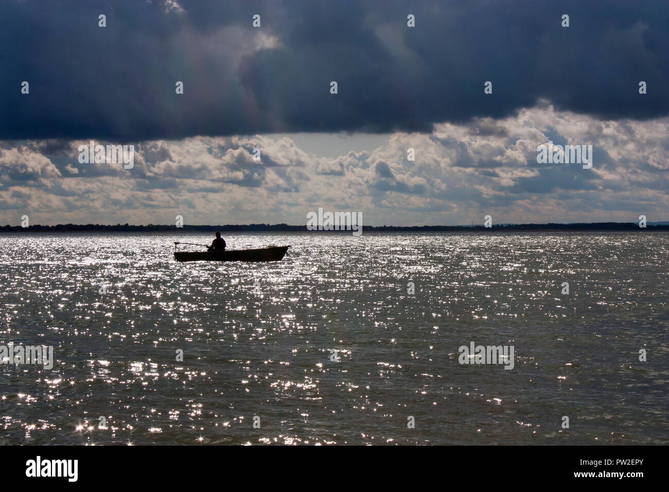 Ein Mann angeln allein in einer kleinen, hölzernen Boot. Ungarn, Plattensee. Stockfoto