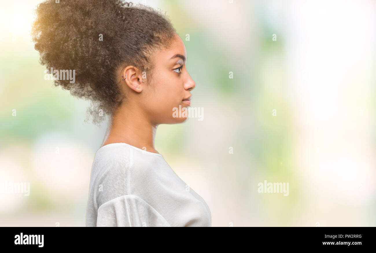 Junge afro-amerikanische Frau über isolierte Hintergrund auf der Suche nach Side, entspannen Profil mit natürliches Gesicht mit selbstbewussten Lächeln darstellen. Stockfoto