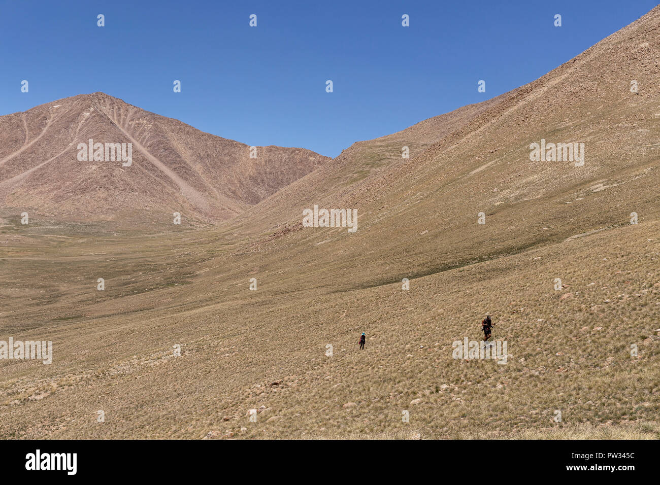 Trekker Abstieg von 4.800 m Bel Airyk Pass mit Zorkul See im Hintergrund auf Trek von Keng Shiber Kara Jilga, Pamir, Tadschikistan. Stockfoto