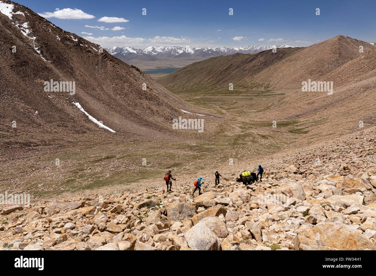 Trekker Abstieg von 4.800 m Bel Airyk Pass mit Zorkul See im Hintergrund auf Trek von Keng Shiber Kara Jilga, Pamir, Tadschikistan. Stockfoto