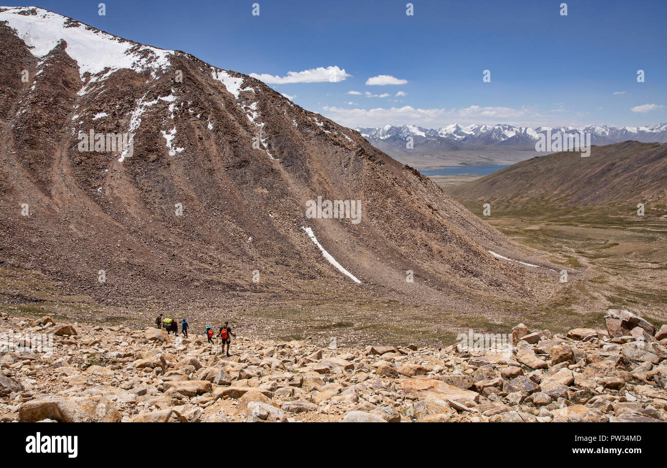 Trekker Abstieg von 4.800 m Bel Airyk Pass mit Zorkul See im Hintergrund auf Trek von Keng Shiber Kara Jilga, Pamir, Tadschikistan. Stockfoto