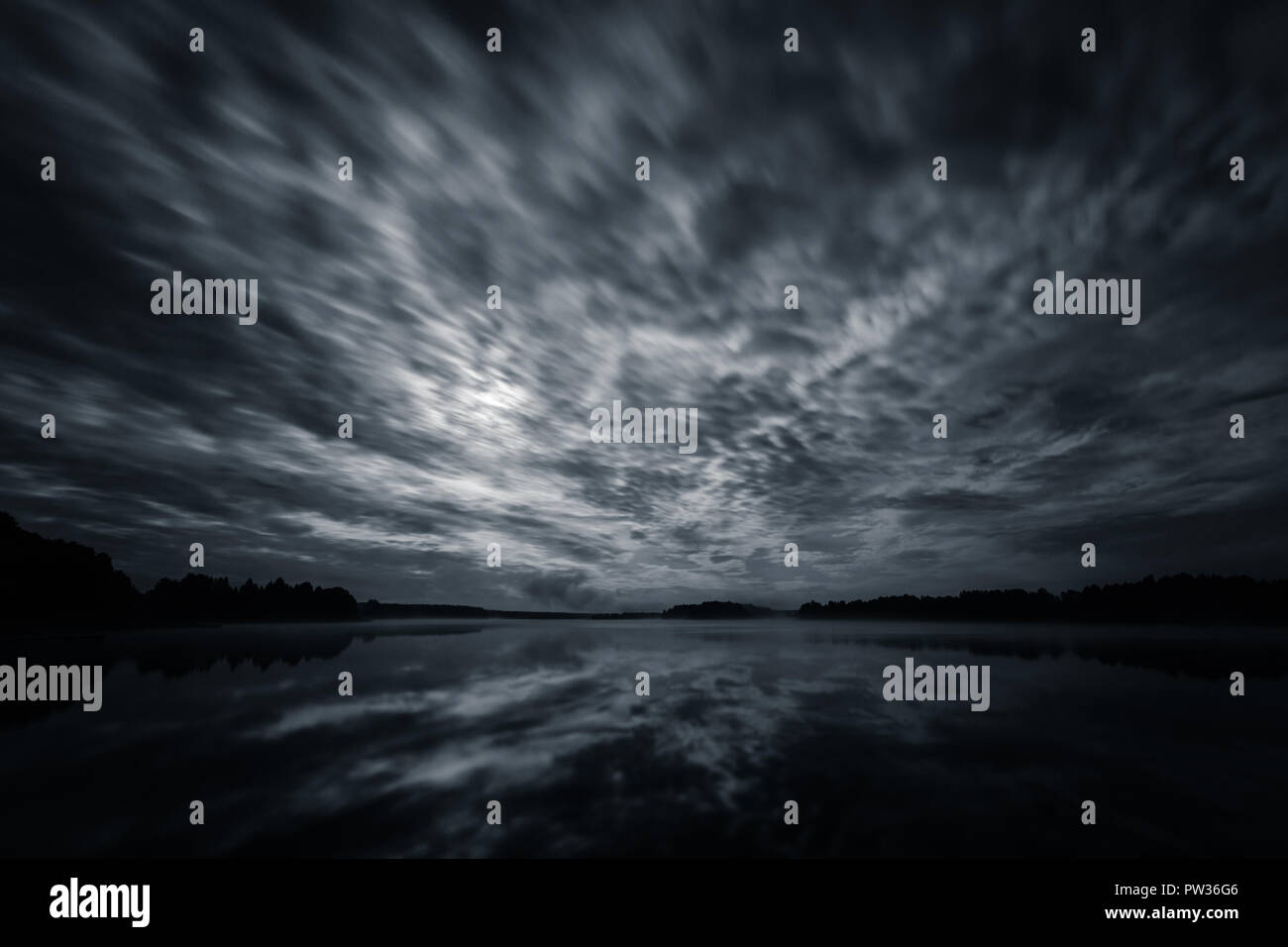 Dynamische Wolken in der Nacht über den See leuchtet bei Vollmond, Langzeitbelichtung Schuss Stockfoto