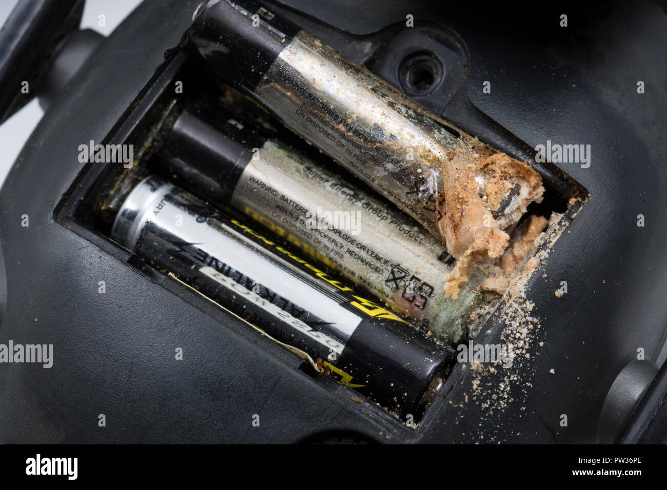 Eine alkalische AAA-Batterie, die für mehrere Jahre in ein paar elektronische Gehörschutz verlassen wurde und tropfte vom Minuspol der Batterie Stockfoto