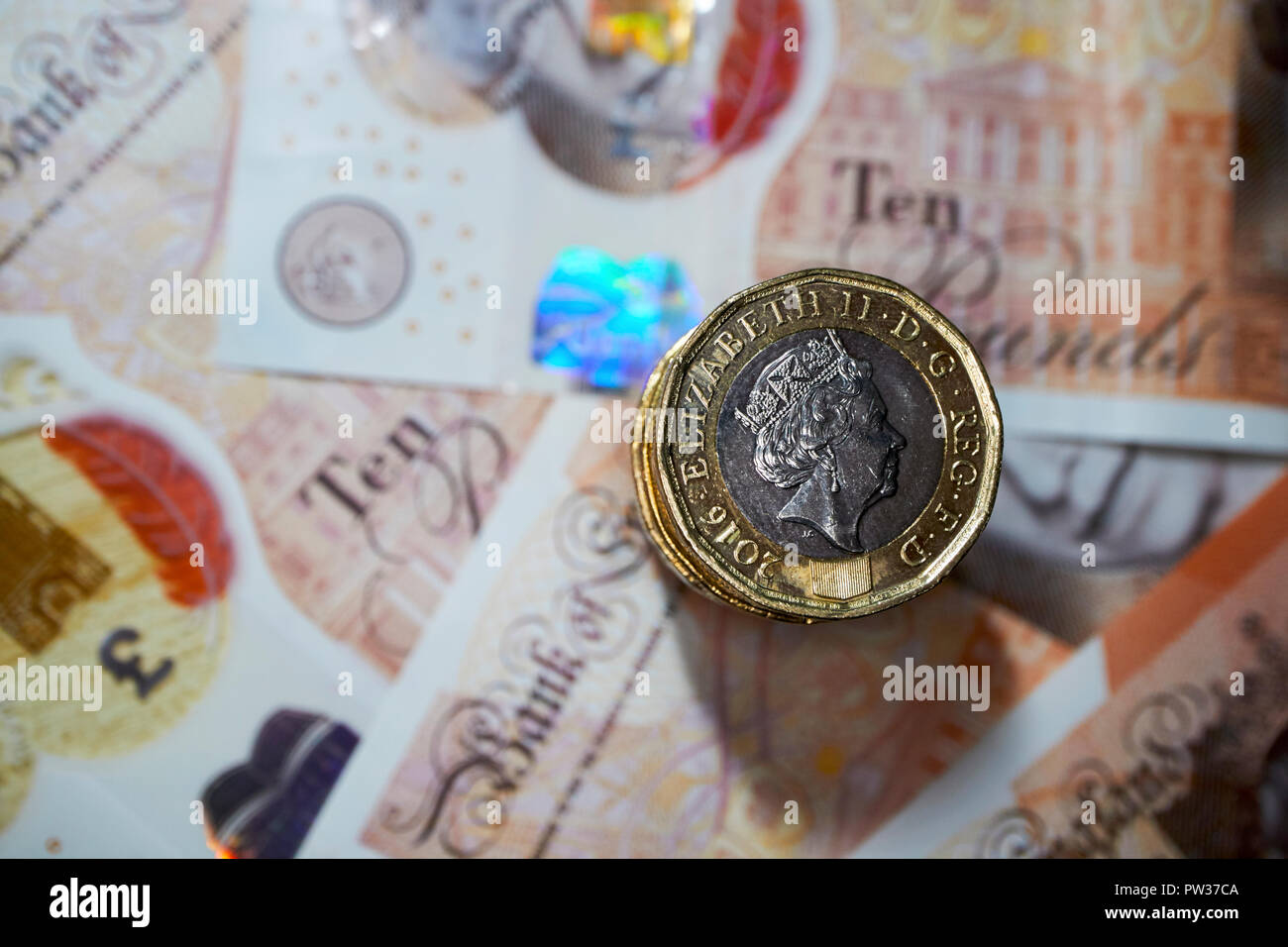 Stapel von Pfund Münzen auf Kunststoff zehn Pfund Noten Stockfoto