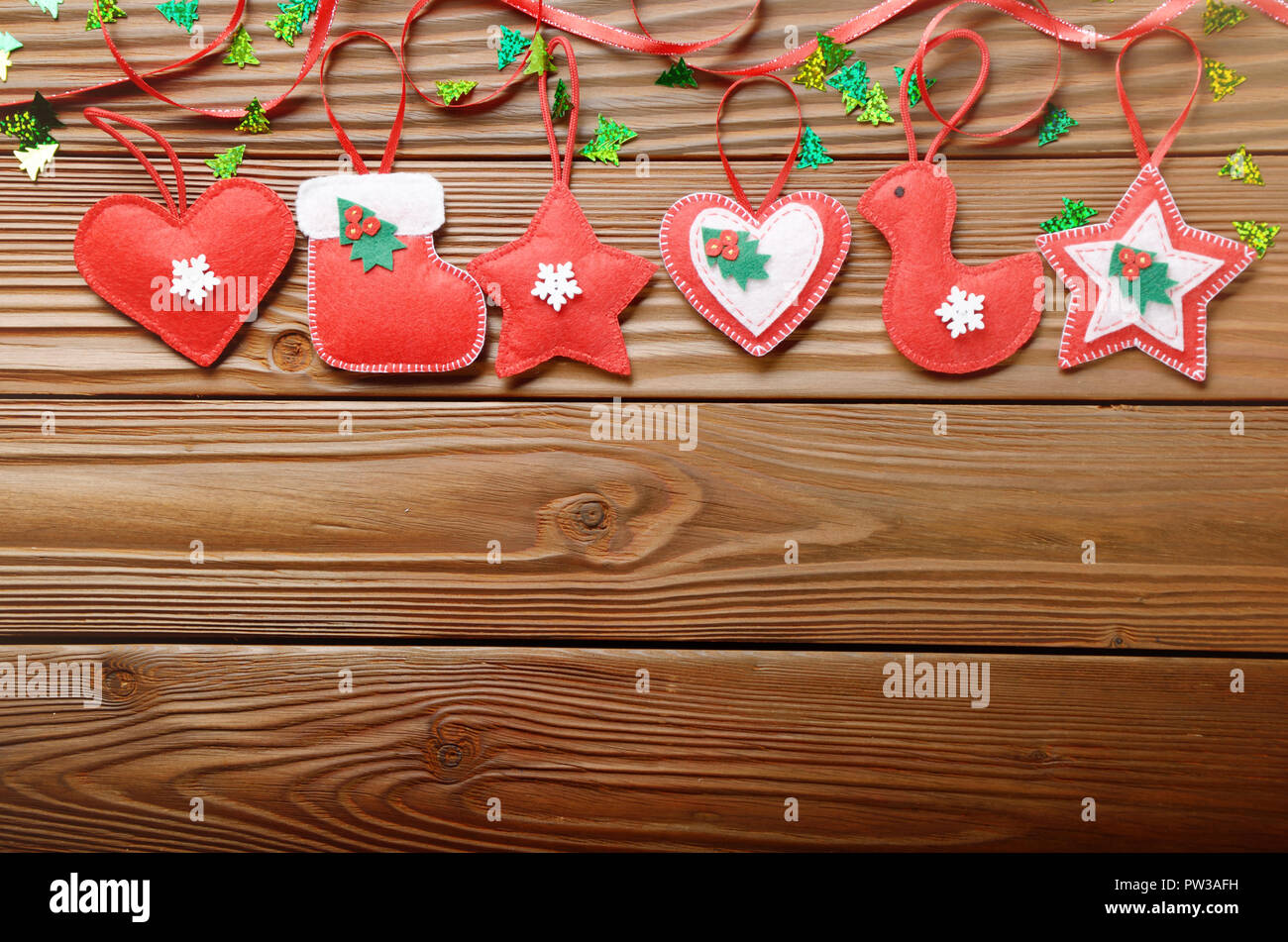 Handgefertigte rustikalen rotem Filz Christbaumschmuck liegend auf hölzernen Tisch Stockfoto