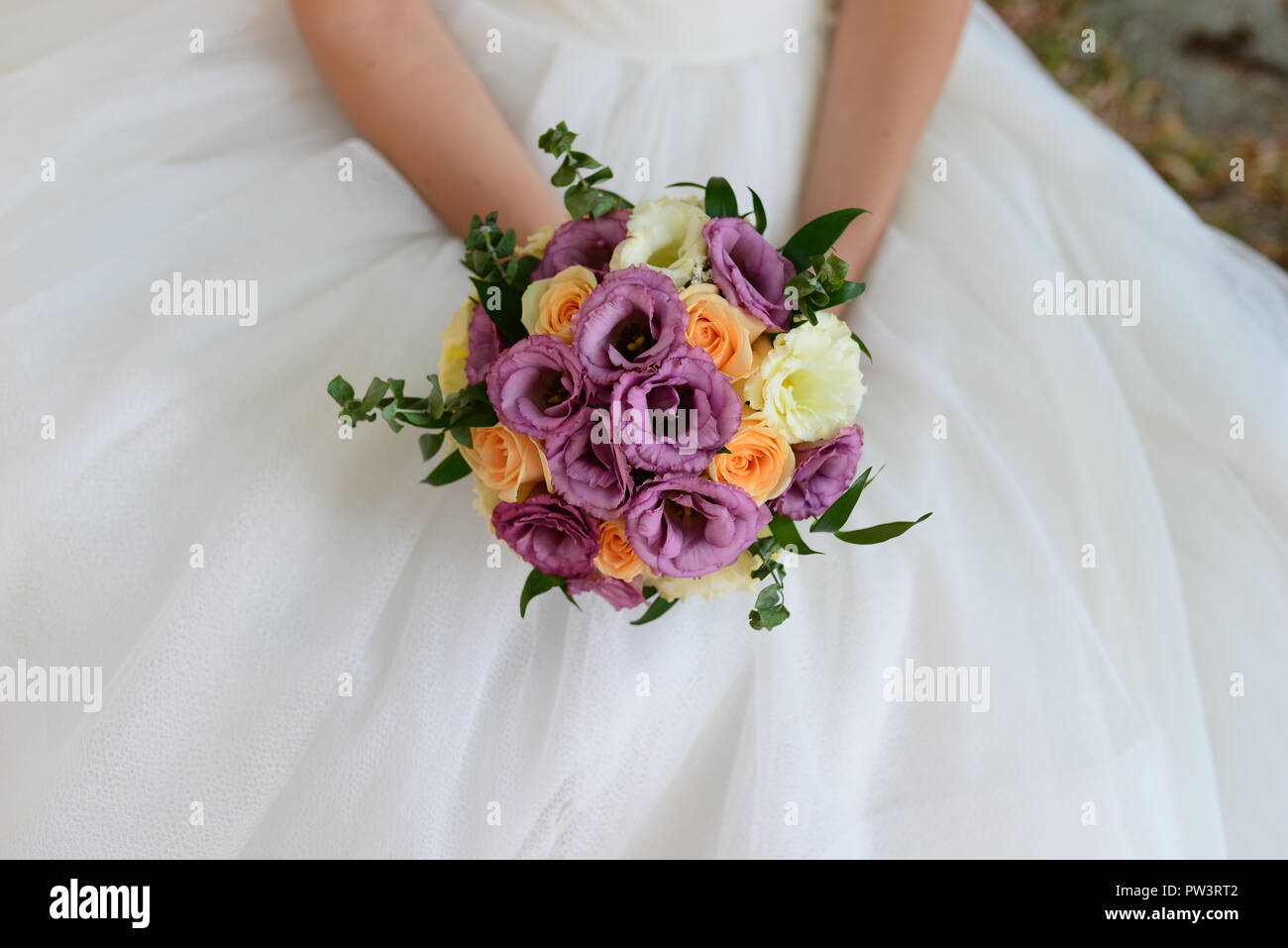 Ansicht von oben Braut flower bouquet über weiße Kleid Stockfoto