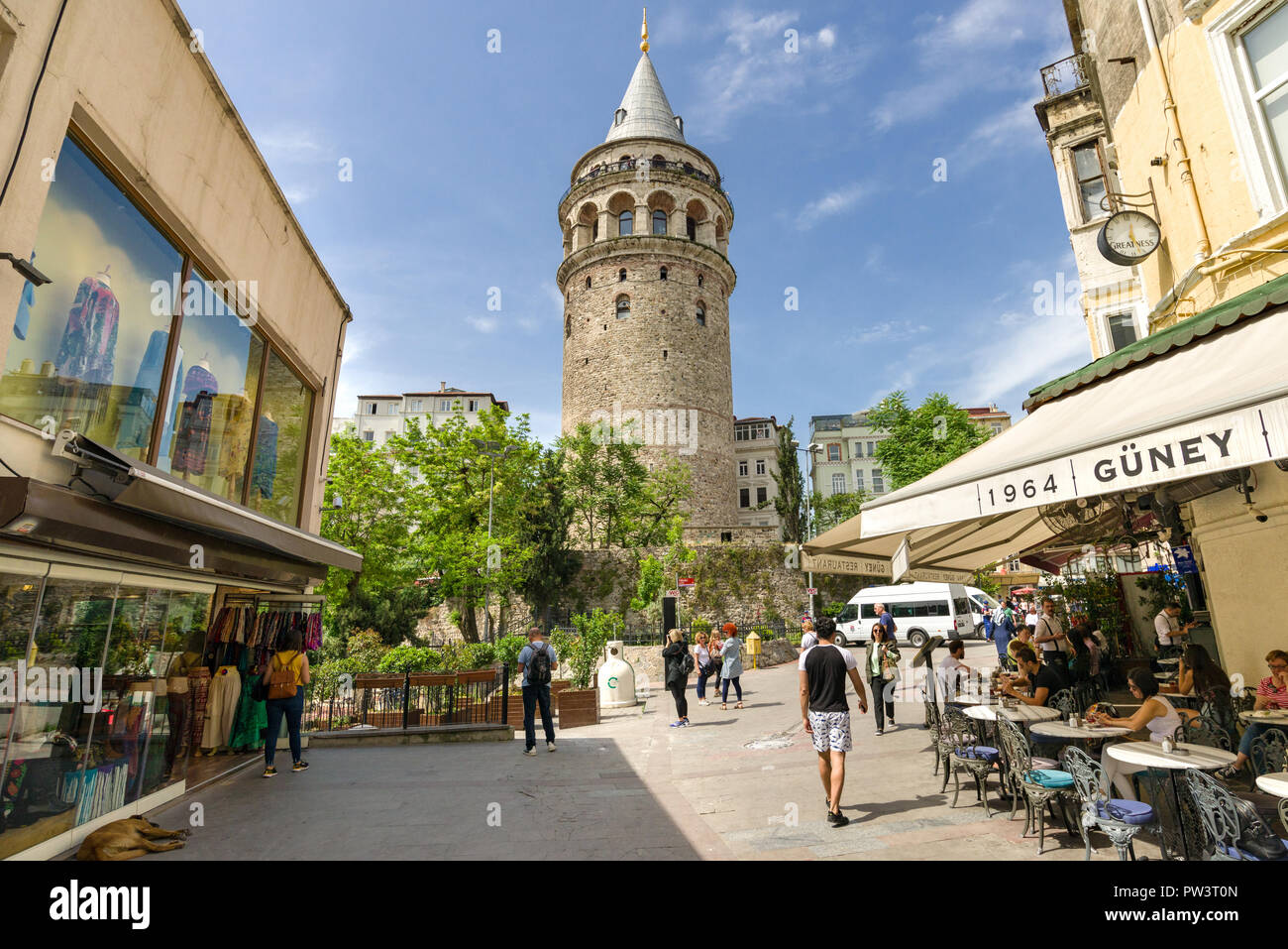 Galata Turm dominiert die Skyline als Menschen außerhalb in einem Cafe an einem sonnigen Frühlingstag, Istanbul, Türkei Stockfoto