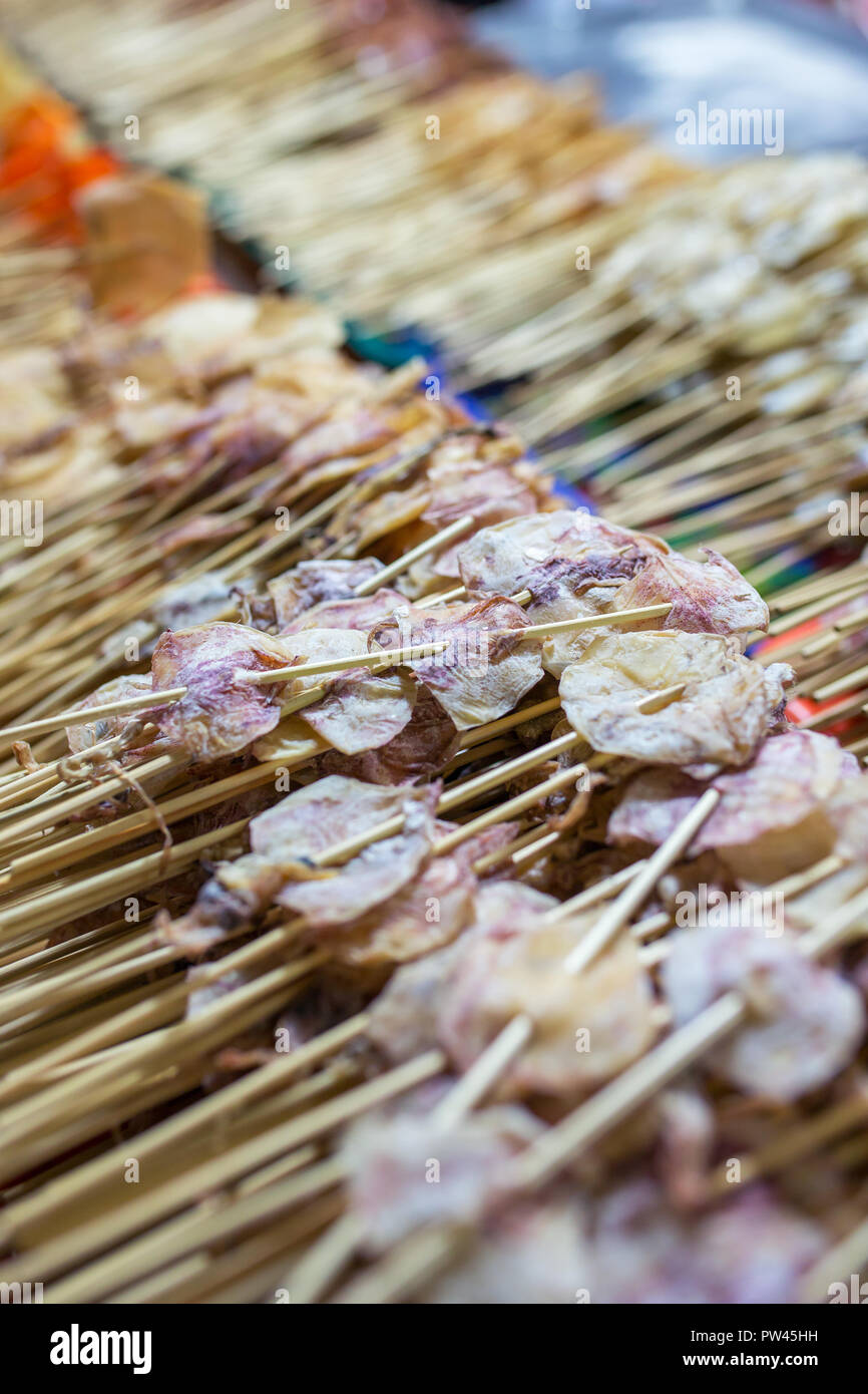 Close-up Sticks trockener Tintenfisch auf der Straße Markt in Thailand. Traditionelle Thai Street Food Stockfoto