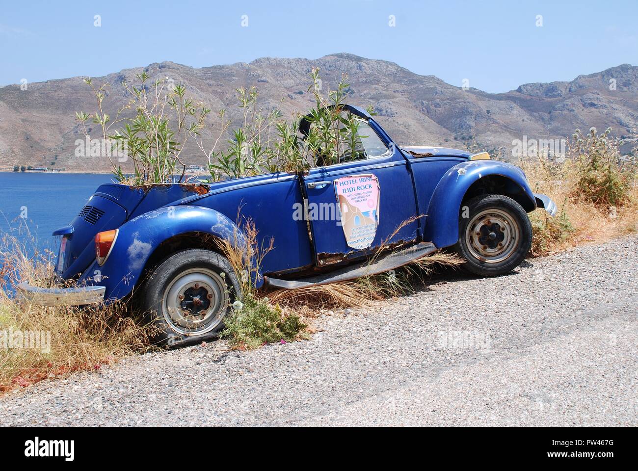 Eine alte verlassene Volkswagen Beetle Auto mit Sträuchern wachsenden innen am Livadia auf der griechischen Insel Tilos am 15. Juni 2018. Stockfoto