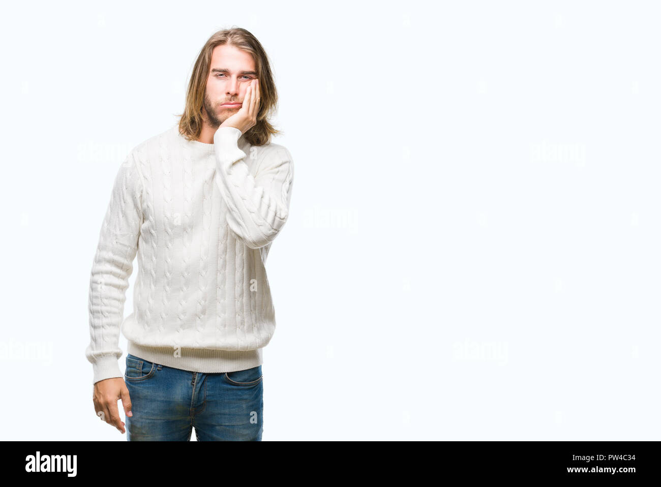 Junger stattlicher Mann mit langem Haar zu tragen winter Pullover über isolierte Hintergrund denken müde und mit Depressionen Probleme mit Kreuz gebohrt Stockfoto