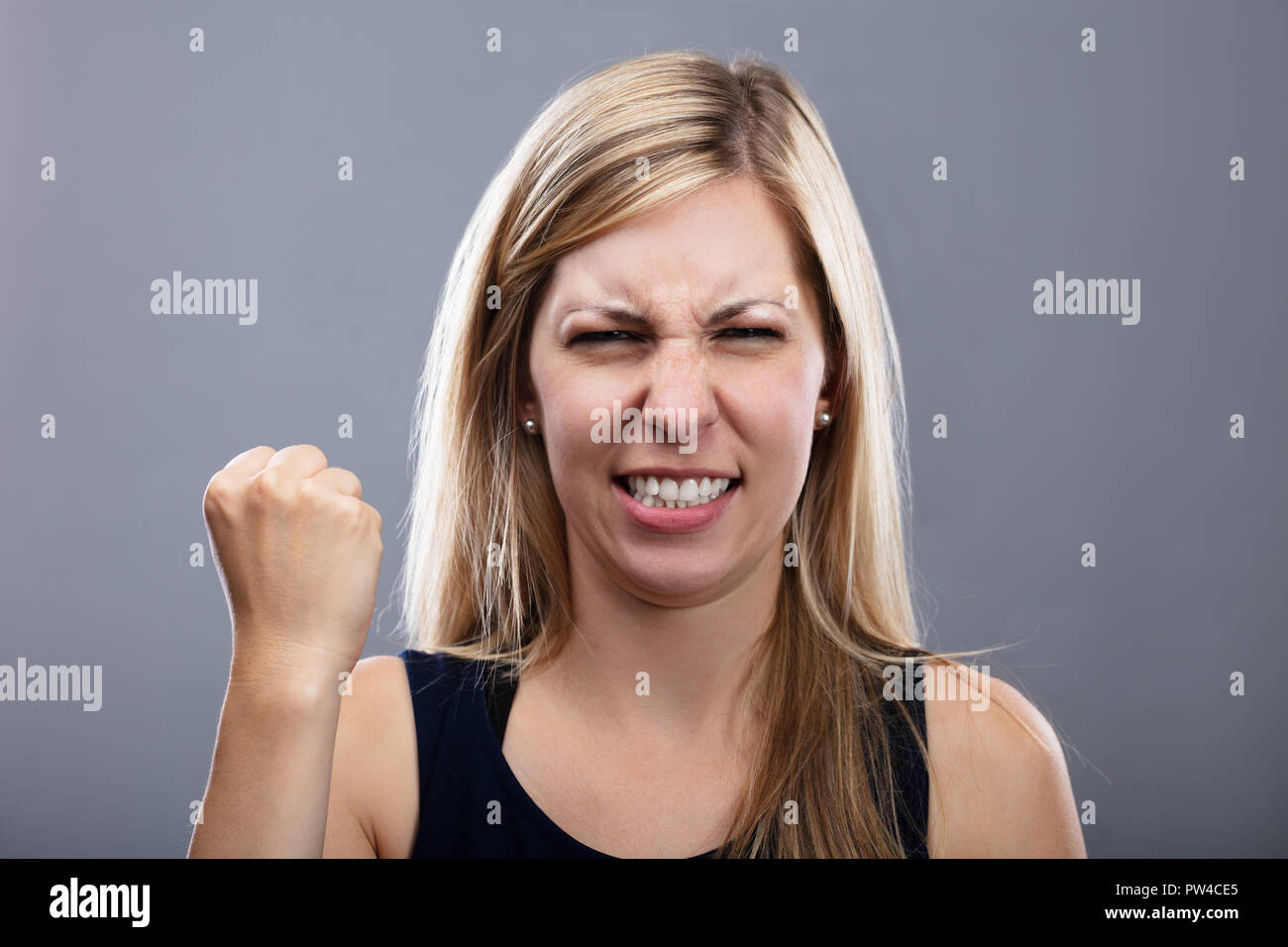 Foto von wütenden jungen Frau auf grauem Hintergrund Stockfoto