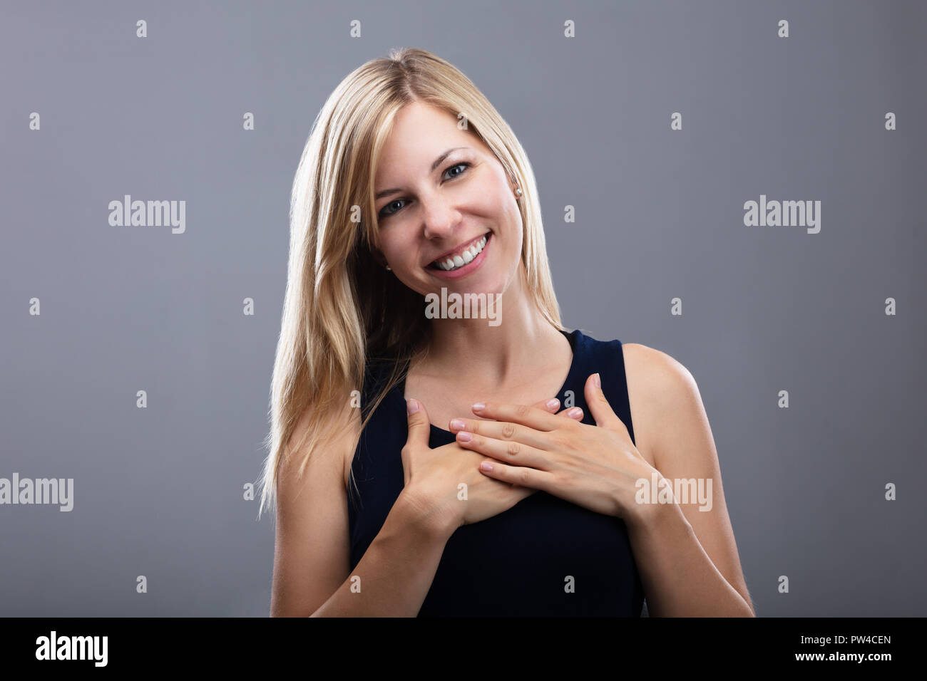 Portrait eines glücklichen jungen Frau auf grauem Hintergrund Stockfoto