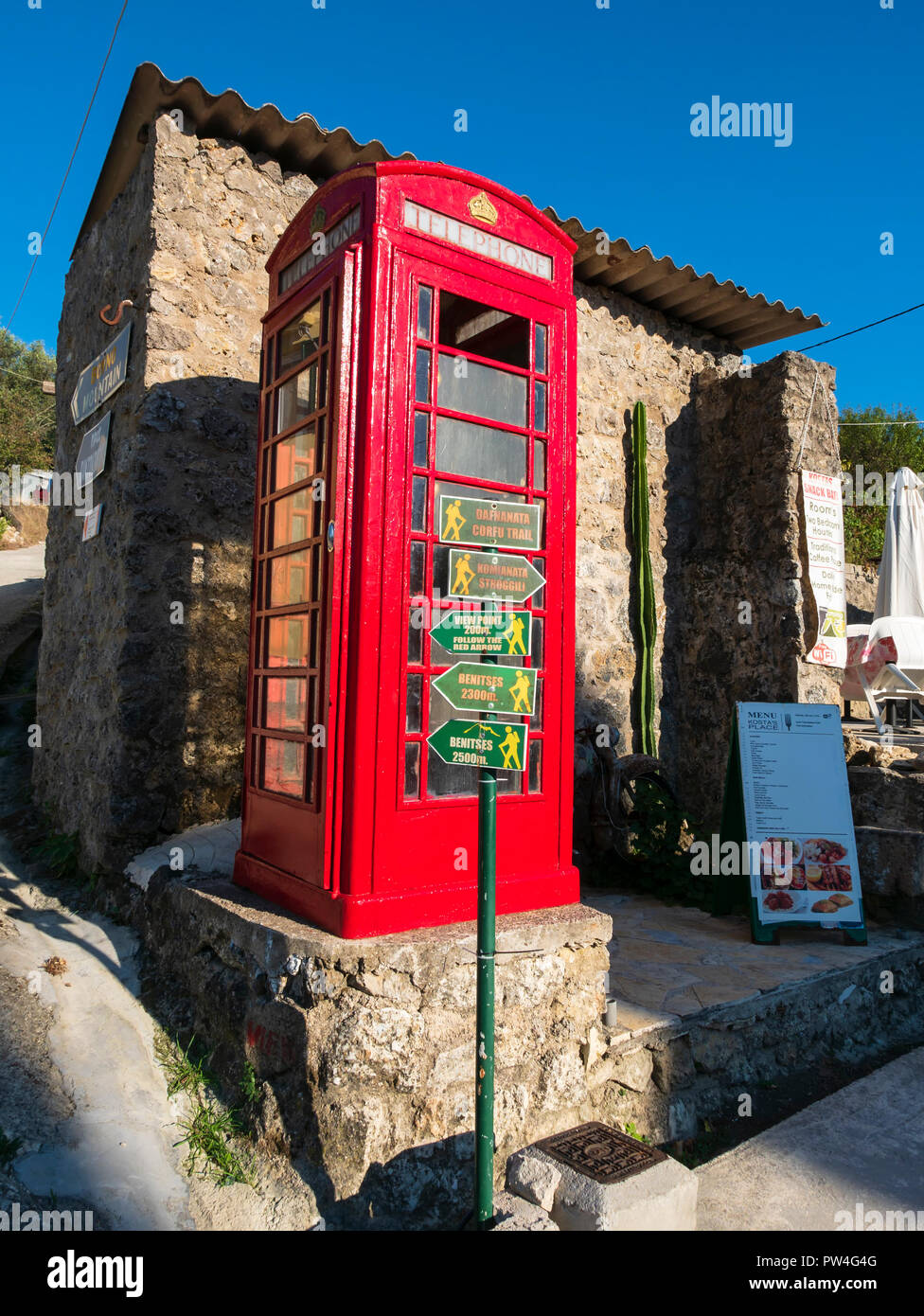 Traditionelles rotes Britische Telefonzelle auf dem Corfu Trail im Dorf Dafnata, Korfu, Ionische Inseln, Griechenland. Stockfoto