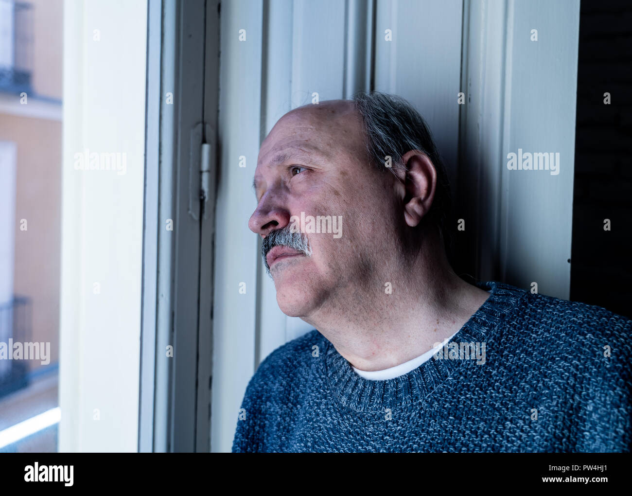 Älterer Mann in seinem 60s Gefühl verzweifelt traurig schauen den ganzen Balkon gesorgt nachdenkliche und einsam zu Hause in alternden Depression Psychische gedrückt Stockfoto