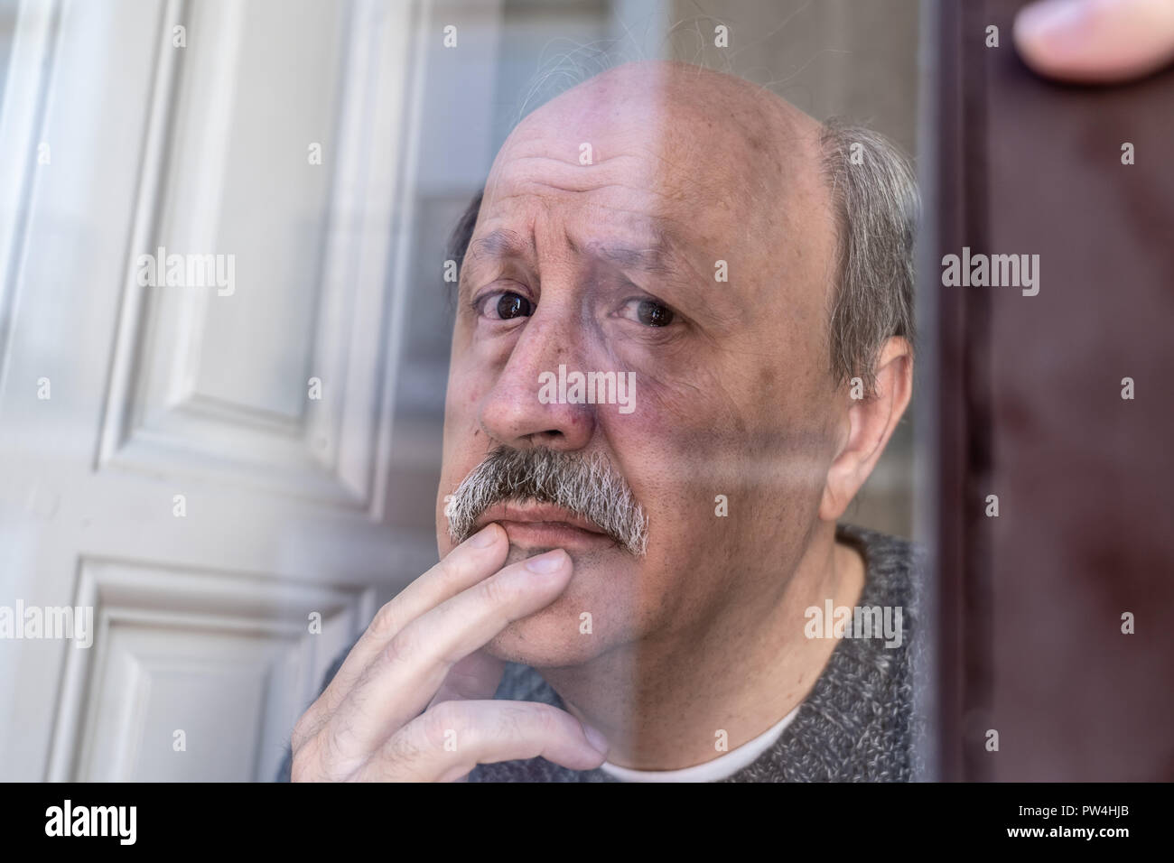 Älterer Mann in seinem 60s Gefühl verzweifelt traurig schauen den ganzen Balkon gesorgt nachdenkliche und einsam zu Hause in alternden Depression Psychische gedrückt Stockfoto